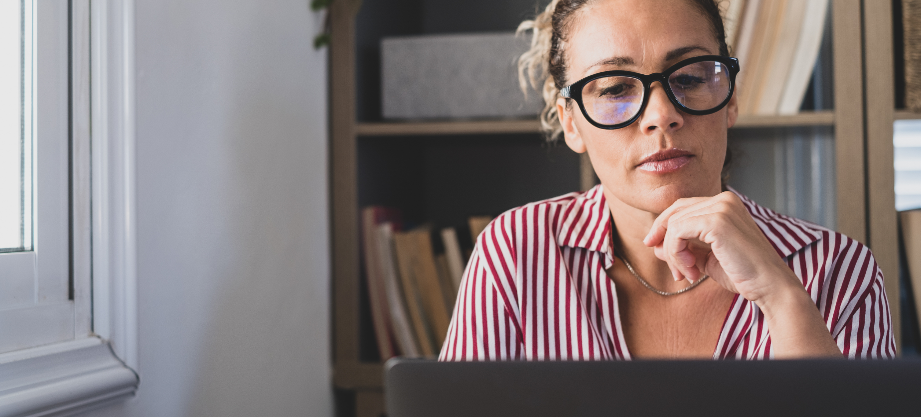 Woman with glasses looking at laptop