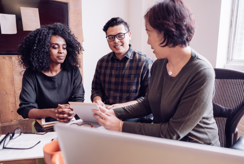 2 women and 1 man discussing over a notepad