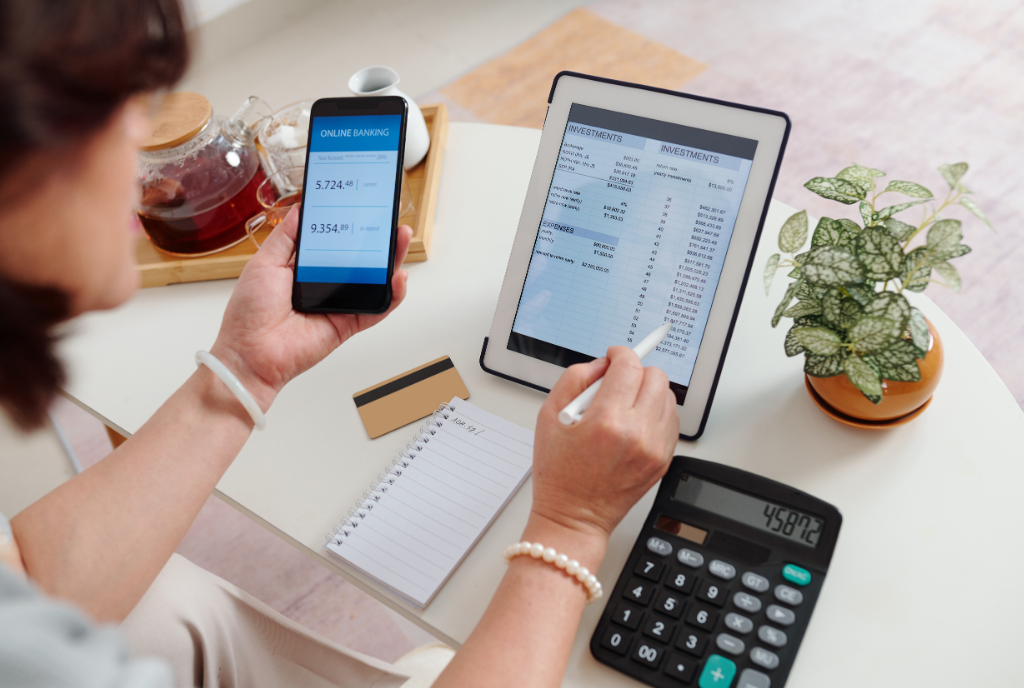 Women looking at tablet, phone and calculator with finances