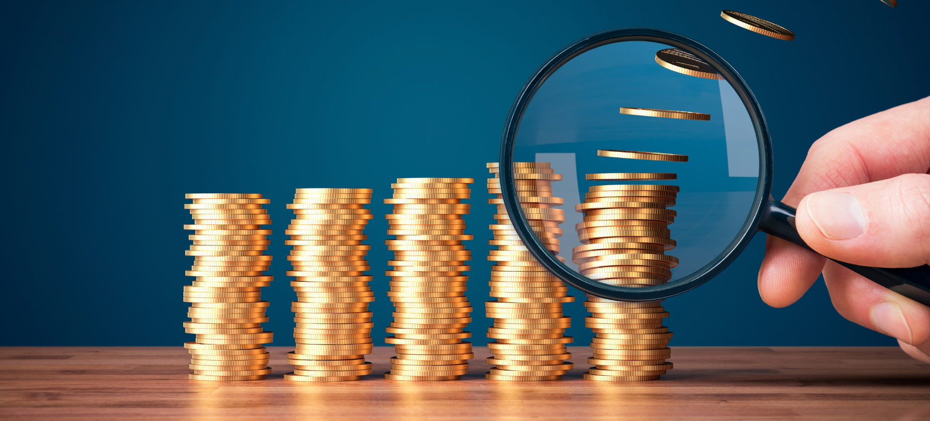 magnifying glass looking at stack of coins