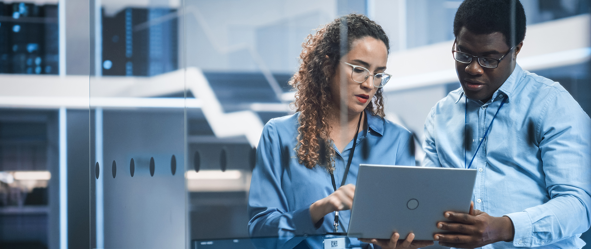 coworker looking at a laptop in a factory
