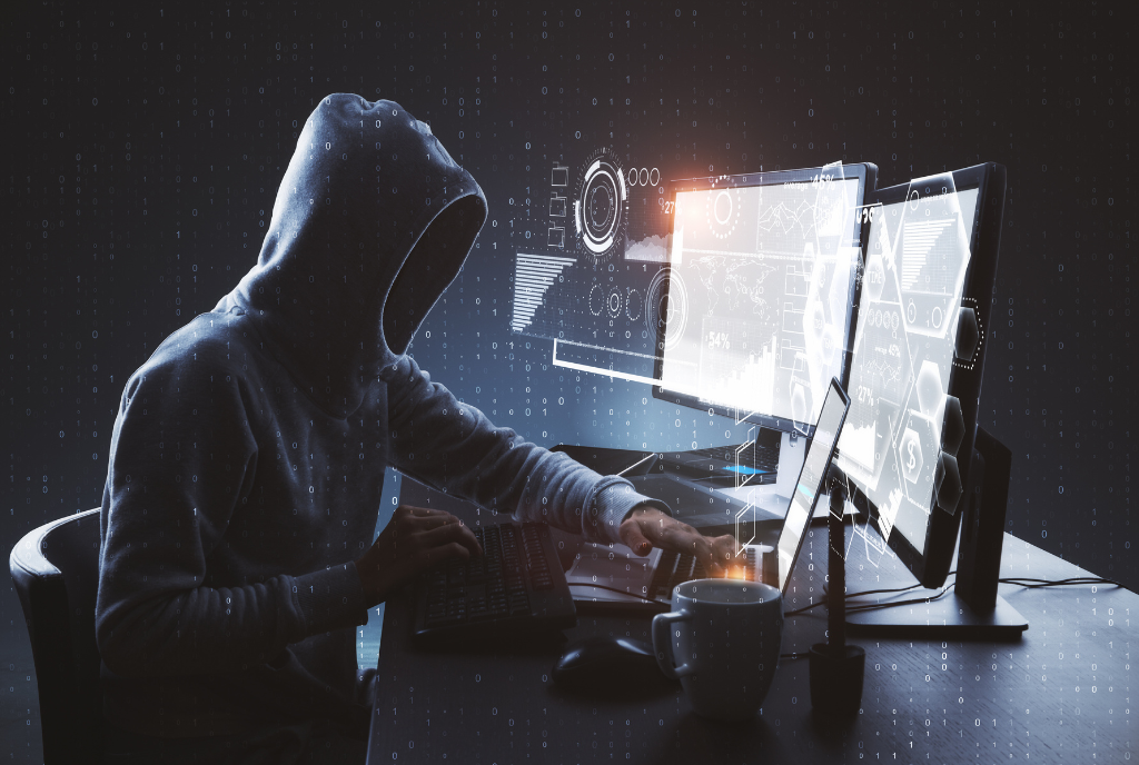 man in hoodie hacking laptop