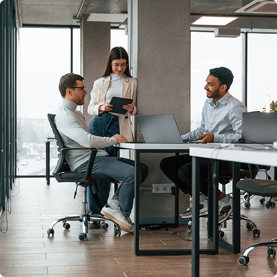 Smiling and talking. Men and woman are working in the office together.