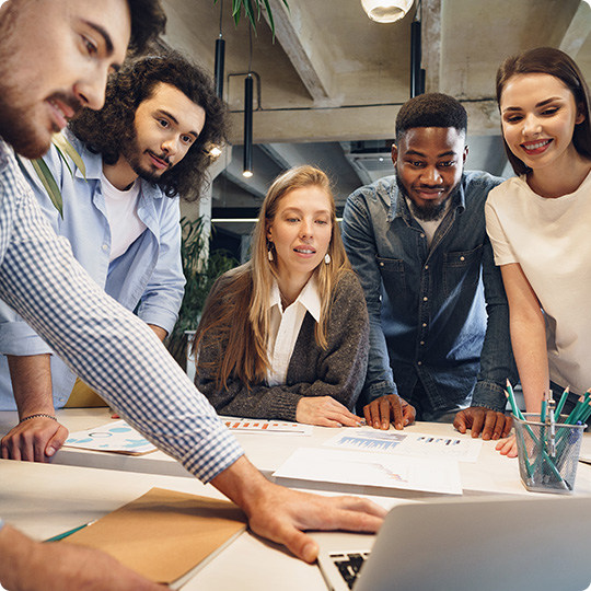 Team of diverse coworkers in modern office discuss their project together