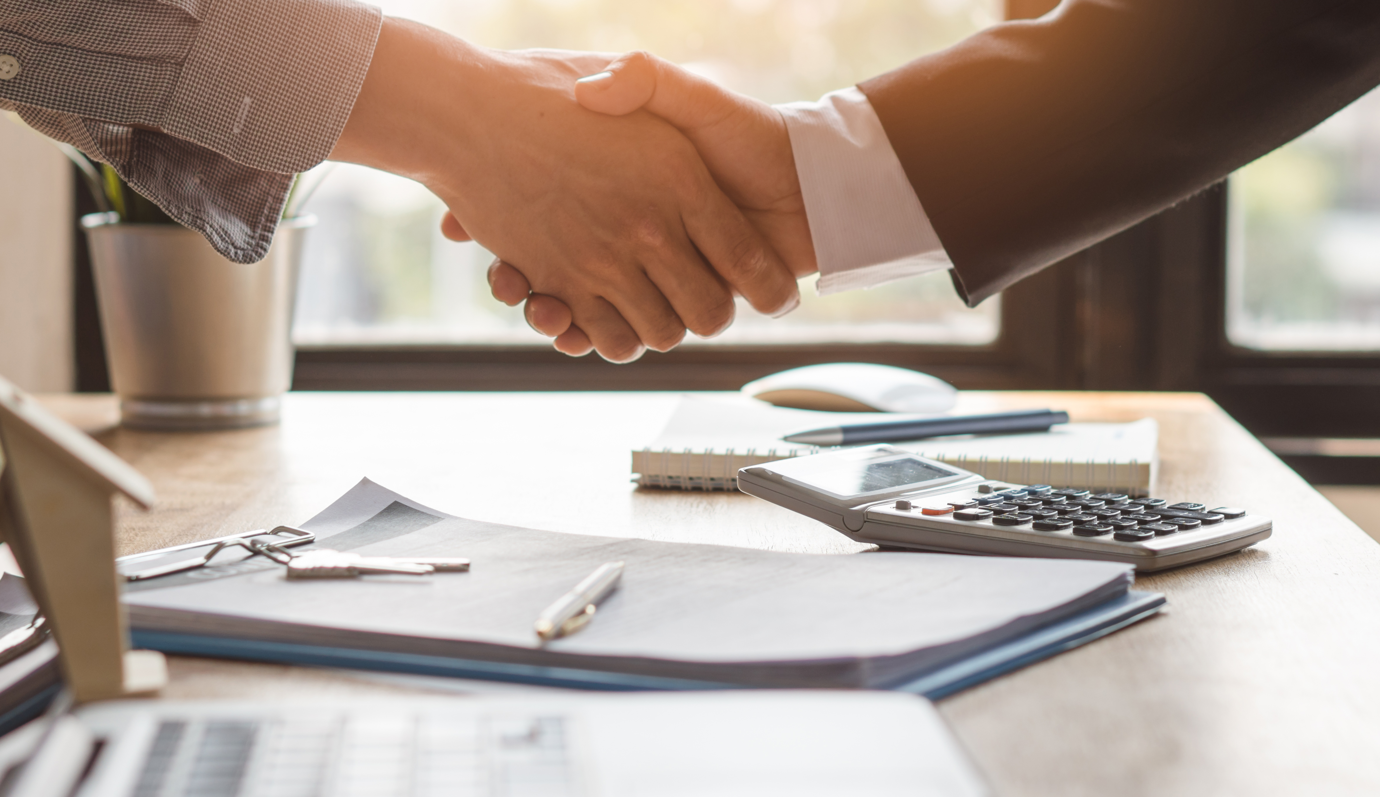 Handshake on top of desk Handshake on top of desk