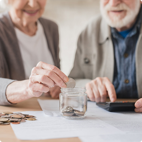Elder people adding money to piggy bank