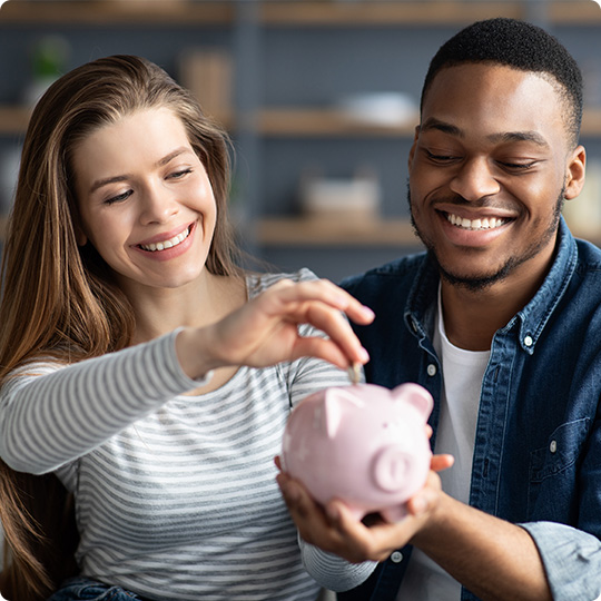 two people adding to piggy bank