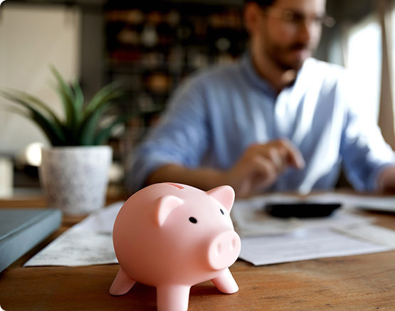man at desk with piggy bank