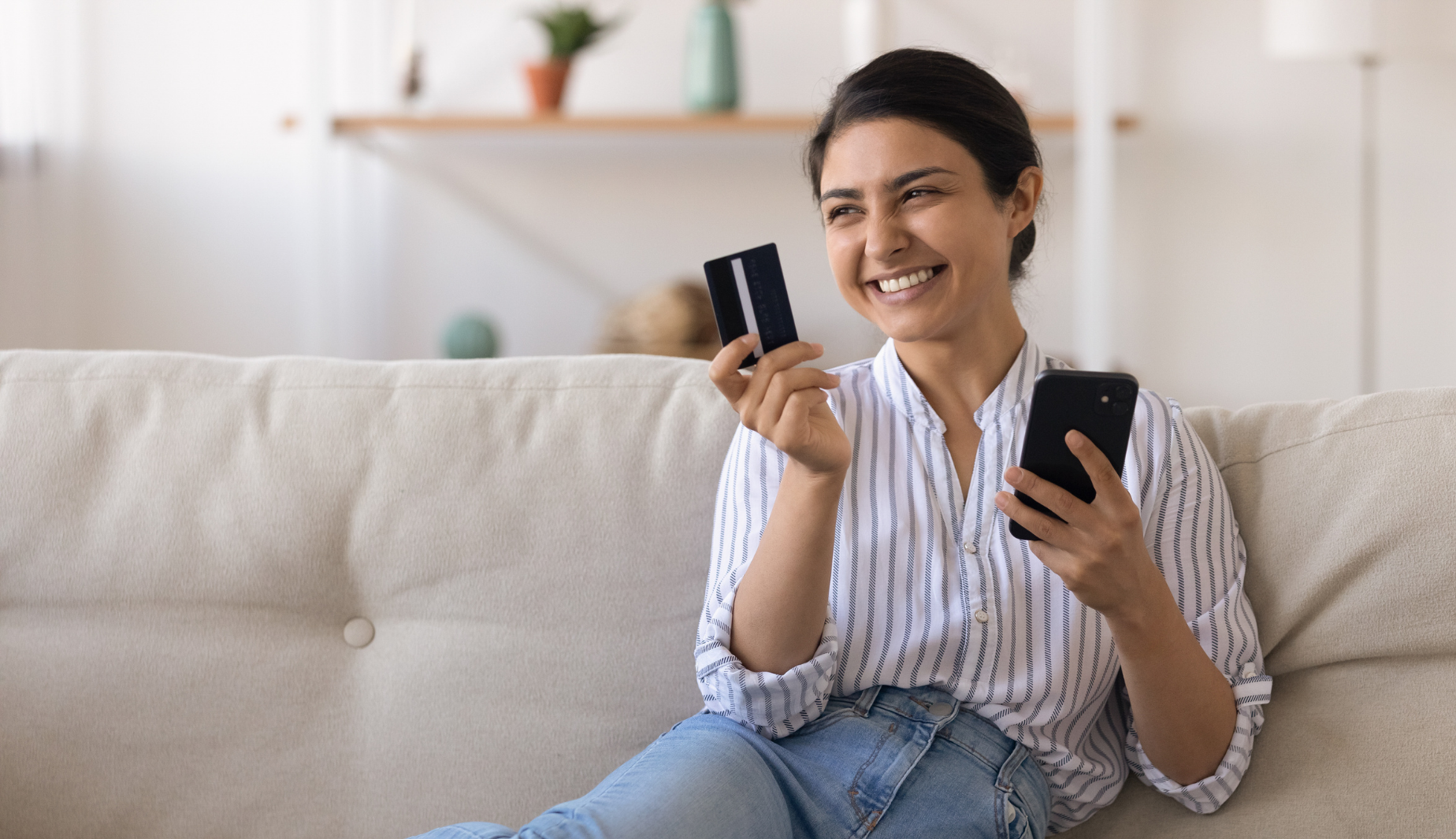 Woman smiling holding phone and card