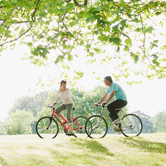 Couple riding bicycles in park