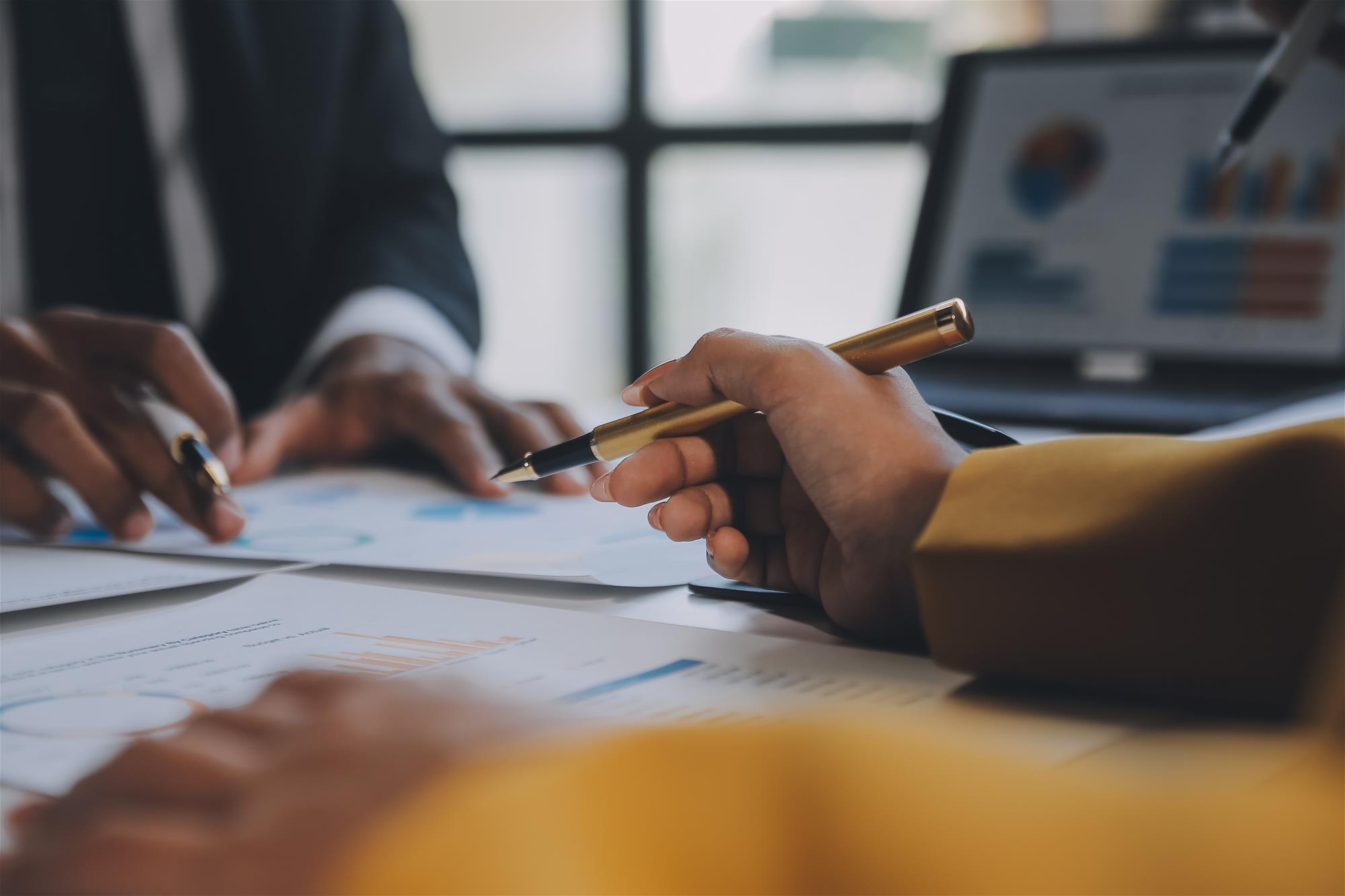 Close up on professionals analyzing business reports on a digital tablet