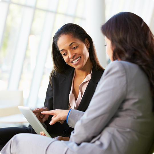 two women looking at computer smiling