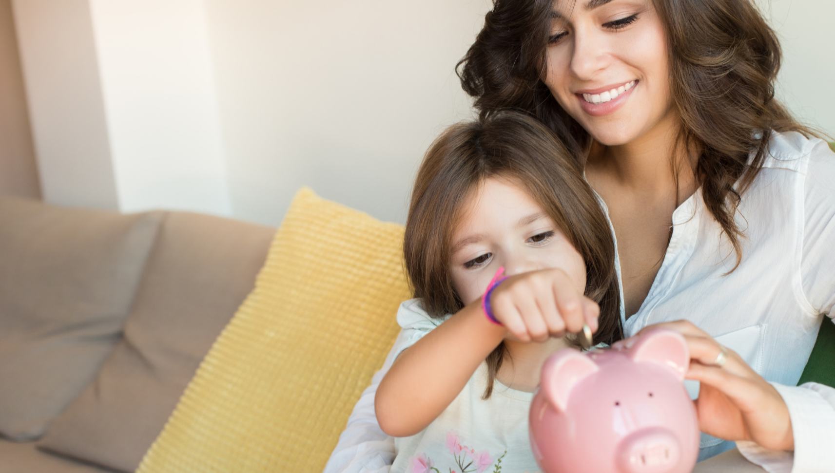 Woman with child adding money to piggy bank