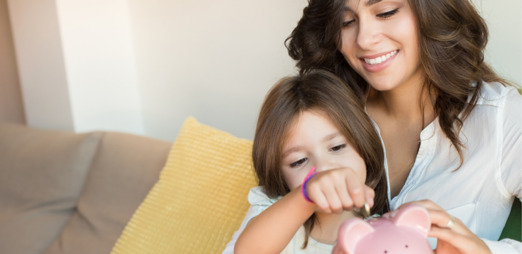 Woman with child adding money to piggy bank