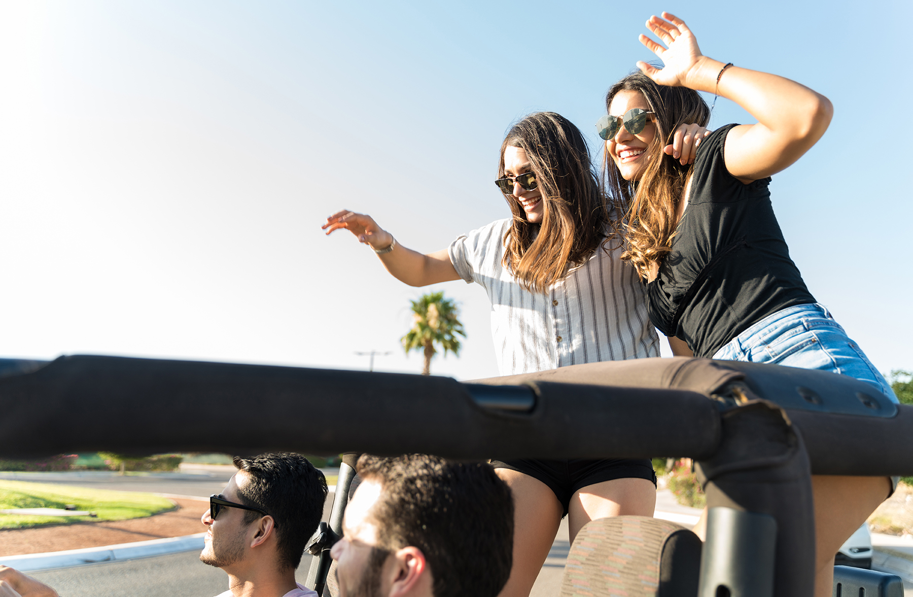 friends standing on car celebrating